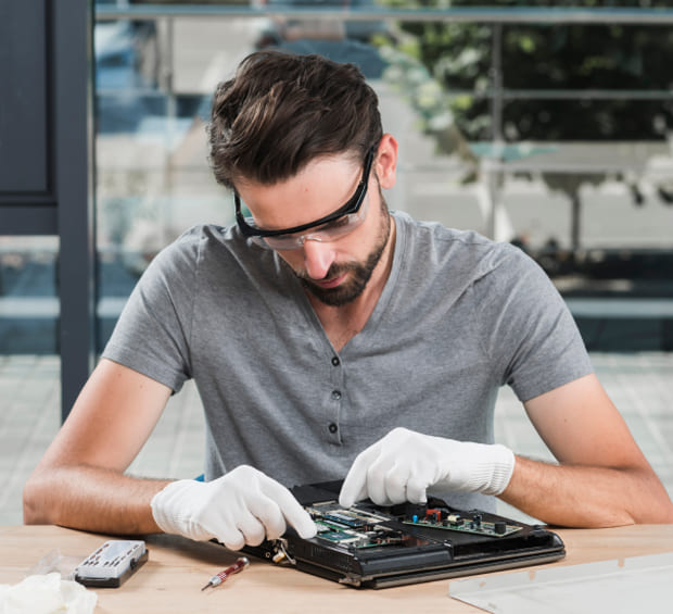 IT-technician-repairing-a-laptop-on-a-workbench
